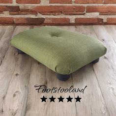 a footstool with four stars on the floor next to a brick wall and wooden floors