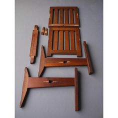 four pieces of wooden furniture sitting on top of a gray floor next to each other