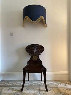 a chair sitting in front of a wall with a clock on it's side