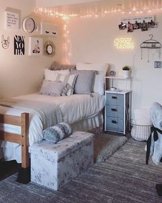 a bed room with a neatly made bed and lots of lights on the wall above it