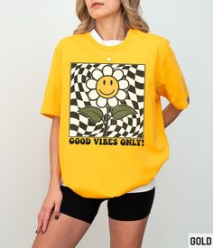 Our retro smiley face graphic tee features a vintage inspired daisy flower happy face checkered design. Our crewneck pairs perfectly with other matching size and style variations (linked below). ✩ ✩✩ The color of graphic is dependent upon the color of shirt that is chosen. Please see pictures for examples. ✩ 𝗧𝗼𝗱𝗱𝗹𝗲𝗿 𝗕𝗲𝗹𝗹𝗮 𝗖𝗮𝗻𝘃𝗮𝘀 𝗧𝗲𝗲: https://starrieapparel.etsy.com/listing/1753557350 ✩ 𝗞𝗶𝗱𝘀 𝗕𝗲𝗹𝗹𝗮 𝗖𝗮𝗻𝘃𝗮𝘀 𝗧𝗲𝗲: https://starrieapparel.etsy.com/listing/175355563 Groovy Short Sleeve T-shirt With Funny Print, Groovy Graphic Print Short Sleeve T-shirt, Trendy Short Sleeve T-shirt With Retro Print, Trendy Yellow T-shirt With Funny Print, Groovy Short Sleeve Top With Graphic Print, Groovy Graphic Print Top With Short Sleeves, Groovy Cotton Tops For Streetwear, Casual Yellow Top With Retro Print, Spring Retro Print Tops For Streetwear