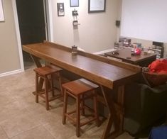 an empty room with two stools and a bar in the middle, next to some pictures on the wall