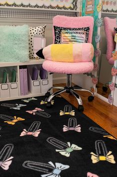 a pink chair sitting on top of a wooden floor next to a book shelf filled with books