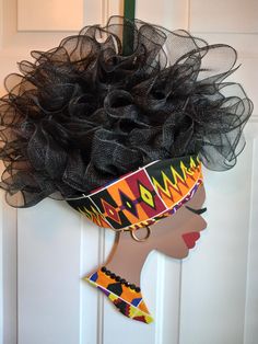 a woman's head is adorned with black mesh and has an afro wig on it