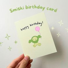 a person holding up a card with a monkey on it that says, happy birthday