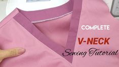 someone is stitching the v - neck on a pink shirt