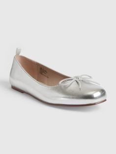 a women's silver ballet shoe with a bow on the front and bottom part