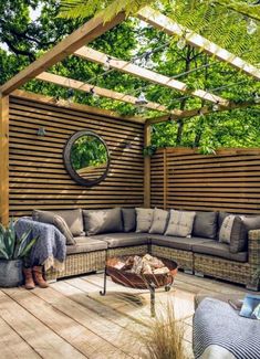 an outdoor living area with couches, tables and potted plants on the deck