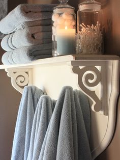 towels and candles are sitting on a shelf