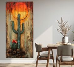 a dining room table with chairs and a painting on the wall above it that has a cactus