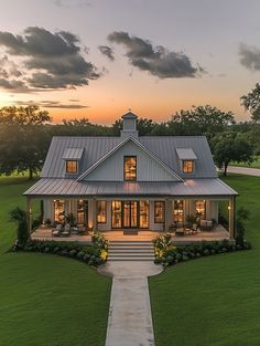 a house that is in the middle of a field with grass and trees around it