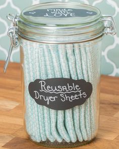 a glass jar filled with white rope on top of a wooden table