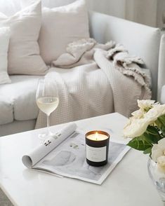 a glass of wine sitting on top of a table next to a vase with flowers