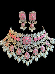 This set comes with gorgeous meenakari choker with matching earrings and is the perfect look for the festive season to glam any event! It come in 4 different colors with gold finishing and kundan work along with pearls to complete the look! Pink Chandbali Bridal Necklace For Festivals, Pink Temple Jewelry Choker For Festive Occasions, Pink Chandbali Bridal Set For Festive Occasions, Festive Pink Jewelry With Zari Work, Festive Pink Zari Work Jewelry, Pink Temple Jewelry Choker For Festive Season, Heavy Pink Kundan Chandbali Necklace, Traditional Pink Kundan Necklace With Zari Work, Pink Kundan Jewelry With Zari Work