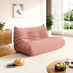 a living room with a pink futon sofa and coffee table in the center area