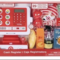 a toy cash register and calculator set in a box with other items around it