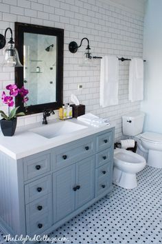 a bathroom with two sinks, a toilet and a large mirror above the sink in it