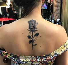 a woman with a black rose tattoo on her back