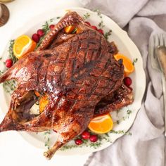 a roasted turkey on a plate with oranges and cranberries