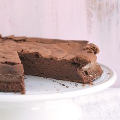 a chocolate cake on a white plate with one slice cut out