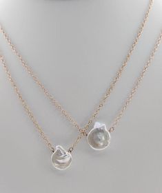 This necklace is a delicate and captivating tribute to the coastal beauty of the ocean's edge. Each Pacific Shell Necklace features meticulously chosen shells, thoughtfully arranged to create a harmonious and timeless piece of jewelry. The shells are a reflection of nature's artistry, with their unique shapes and textures mirroring the ocean's treasures. This necklace is a celebration of graceful simplicity, making it a versatile and elegant addition to your collection. Elegant Mother Of Pearl Shell With Pearl Pendant, Ocean-inspired Shell-shaped Pearl Pendant Jewelry, Pearl White Shell-shaped Pearl Chain Jewelry, Ocean-inspired Shell-shaped Mother Of Pearl Jewelry, Elegant Jewelry With Oyster Bracelet, Ocean-inspired Mother Of Pearl Jewelry With Pearl Charm, Shell Jewelry With Pearl Pendant, Silver Shell Necklaces With Pearl Charm, Mother Of Pearl Shell-shaped Necklace In Pearl White