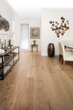 a living room filled with furniture and a wooden floor covered in hard wood planks