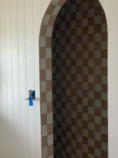 a bathroom with a toilet and tiled shower stall next to a white wall in the corner