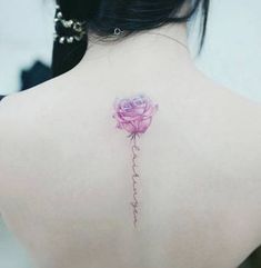 the back of a woman's neck with a pink rose tattoo