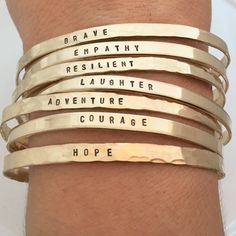 "Inspirational Bracelet - Personalized Cuff Bracelet - Motivational Word Bracelet - Gold Cuff - Inspirational gift for her Intentions Goals uff This listing is for ONE skinny cuff. One hammered gold filled cuff is stamped with the word of your choice in a tiny block font. Up to 20 characters can be stamped on the cuffs. These cuffs are made from 18 gauge sheet, are hammered, stamped, formed and then tumbled for strength and shine. DURING CHECKOUT PLEASE INCLUDE THIS INFO words/names to stamp (up Inspirational Gold Bracelet, Hand Stamped, Inspirational Gold Bracelet Hand Stamped, Inspirational Hand Stamped Gold Bracelet, Hand Stamped Gold Cuff Bracelet For Friendship, Gold Hand Stamped Cuff Bracelet For Friendship, Personalized Inspirational Cuff Bracelet For Everyday, Everyday Inspirational Personalized Cuff Bracelet, Meaningful Hand Stamped Gold Bracelet, Personalized Cuff Bracelets