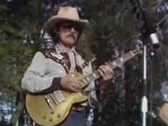 a man in a cowboy hat playing an electric guitar