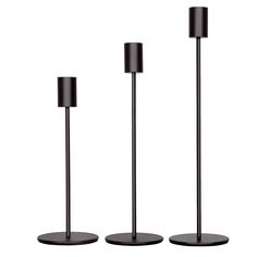 three black candles are standing next to each other