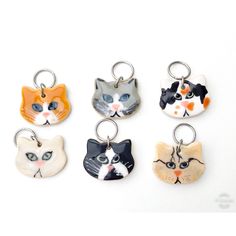 six cat keychains with different colors and designs are shown in the shape of cats