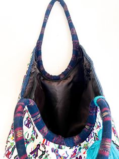 Designed to have everything you wanted in a carry-all tote for your towels, cell-phone, water bottle, this up-cycled tote is designed to be spacious and stylish. Handwoven by skilled artisans in Guatemala, features a geometric pattern and a contrast tassel. Fabric: Huipil from Guatemala One of a kind fabric tassel accents Open top Interior pocket Shoulder straps Black lining for water protection Weight: 12oz / 0.34kg 17 x 17'' approx. Handwoven by women artisans in Guatemala using traditional te Rectangular Hobo Bag With Cell Phone Pocket For Travel, Multicolor Rectangular Bag With Water Bottle Pocket, Multicolor Cotton Hobo Bag For Travel, Travel Tote Canvas Bag With Cell Phone Pocket, Travel Canvas Tote Bag With Cell Phone Pocket, Artisan Tote Beach Bag For Travel, Artisan Beach Bag Tote For Travel, Artisan Beach Tote Bag For Travel, Artisan Travel Beach Bag Tote