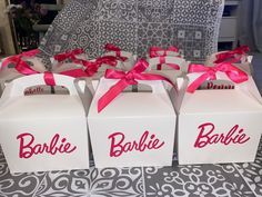 three white boxes with pink ribbon and name on them