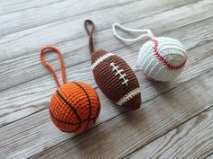 three crocheted sports balls and a basketball on a wooden surface, one with a string