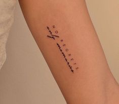 a woman's arm with an arrow tattoo on the left side of her leg