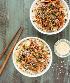 two bowls filled with rice and vegetables next to chopsticks