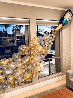 a room decorated with gold and silver balloons