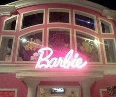 a pink and white building with a neon sign that says barbie