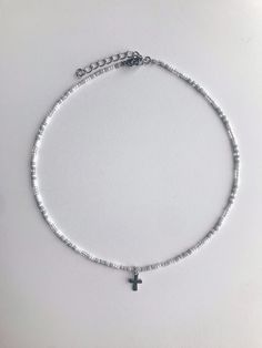 This dainty Seed Bead Choker Necklace with a delicate stainless steel cross charm(the jump-rings that attached to the charm to the necklaces are also stainless steel) is made with pretty multi-colored grey, white, and silver glass seed beads. The tiny seed beads are strung on beading wire & finished with a stainless steel lobster style clasp with a 2 inch stainless steel extension chain, to allow for personal size adjustments. These necklaces are perfect for everyday wear. Enjoy a cute simpl Beaded Necklace With Cross, Silver Seed Bead Necklace, Cross Beaded Necklace, Seed Bead Necklace With Charm, Silver Beads Necklace, Nickel-free White Necklace With Round Beads, White Nickel-free Necklace With Round Beads, Silver Beaded Cross Necklace For Gift, White Hypoallergenic Dangle Necklaces