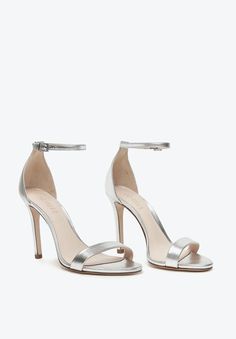 a pair of silver high heeled shoes with ankle strap and two straps on each side