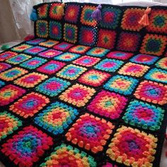 a crocheted blanket is sitting on a bed