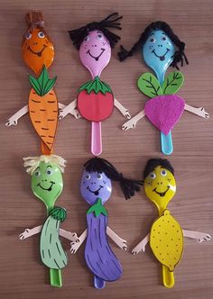 six plastic spoons with cartoon characters on them, each holding different types of vegetables