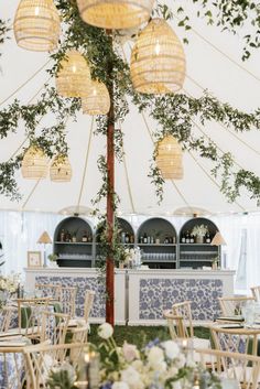 the inside of a tent with tables and chairs set up for an outdoor function or party