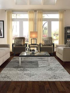 a living room with two couches and a coffee table in front of large windows