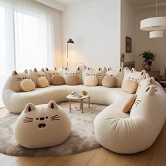 a living room filled with lots of white couches covered in cat pillows and cushions