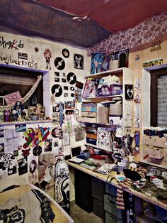 a cluttered room with various items on the wall and shelves full of papers, pictures, and magnets