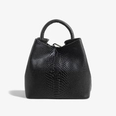 Elevate your accessory collection with our exquisite Black Leather Handbag, featuring a distinctive round handle that adds a modern touch to its classic design. Crafted from genuine leather with an elegant embossed pattern, this handbag is a testament to skilled craftsmanship, meticulously processed in our factory from start to finish. Key Features: Modern Design: The unique round handle and embossed leather pattern create a sophisticated and contemporary look. Premium Materials: Made from high- Elegant Satchel Bucket Bag For On-the-go, Elegant Handheld Bucket Bag For On-the-go, Luxury Handheld Bucket Bag For On-the-go, Chic Handheld Satchel With Textured Leather, Luxury Bucket Bag With Top Carry Handle, Elegant Textured Leather Hobo Bag, Formal Handheld Bag In Textured Leather, Formal Textured Leather Handheld Bag, Versatile Textured Leather Top Handle Bag