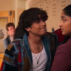 two young people standing next to each other in front of lockers and locker doors