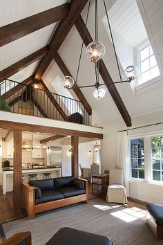 a living room filled with furniture next to a kitchen